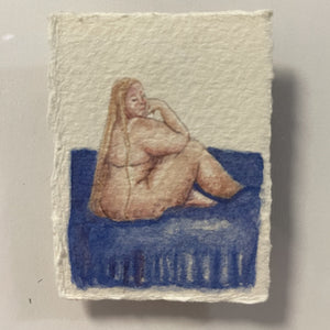 a miniature nude of a white woman with blond hair, sat on a blue draped bed